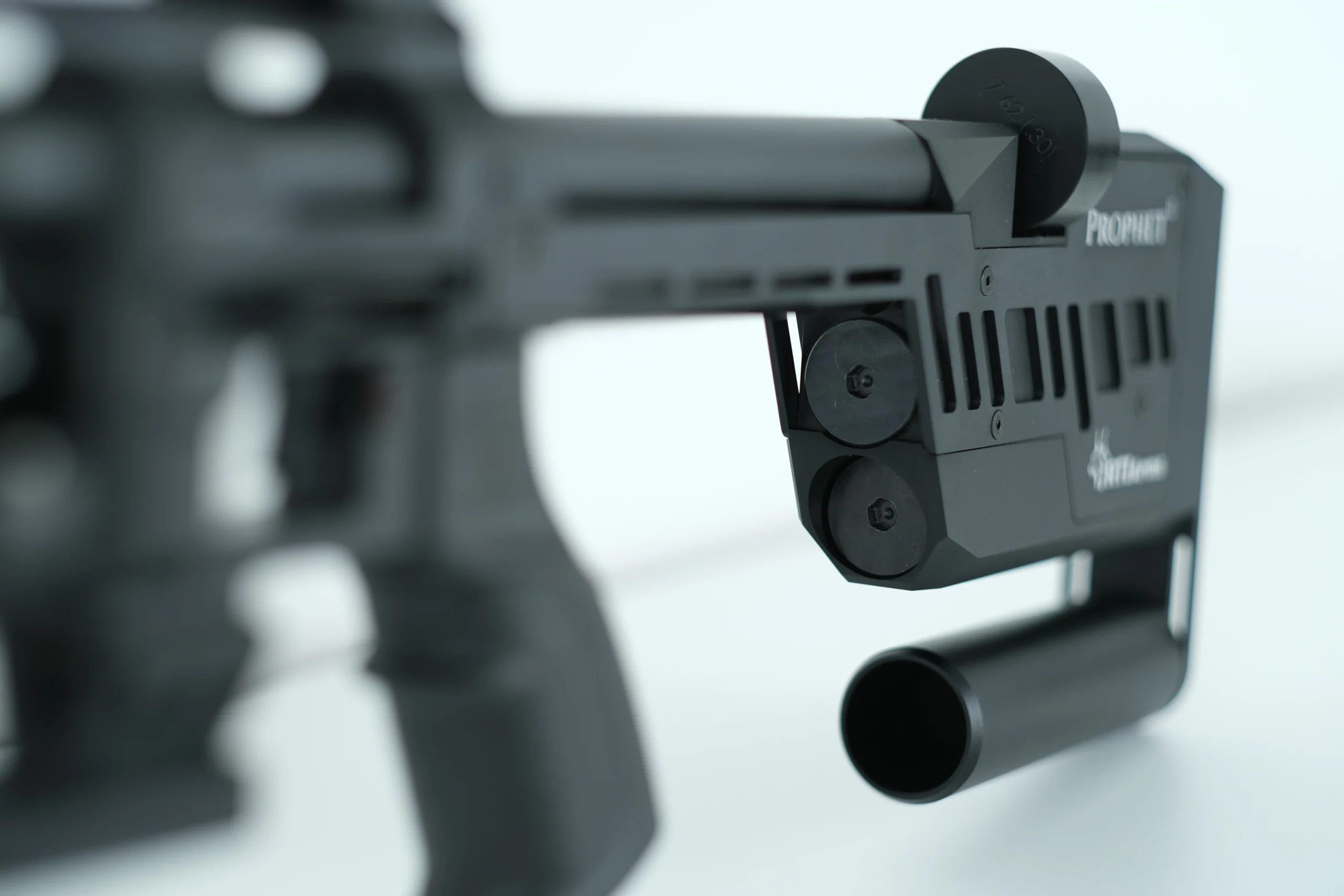 RTI P-3 Performance PCP Air Rifle 3 Close-up of the black RTI P-3 PCP Air Rifle with an adjustable stock, sleek metal components, and a cylindrical attachment on a white background.