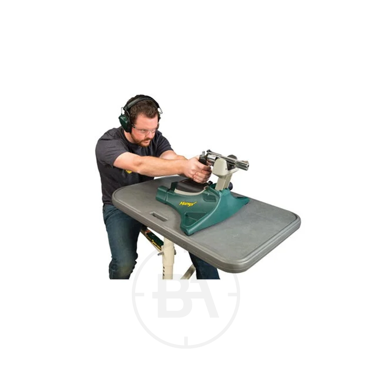 Caldwell Matrix Shooting Rest 3 A man wearing ear protection sits at a shooting bench, aiming a pistol supported by a green Caldwell Matrix Shooting Rest.