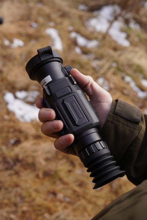 HIKMICRO Thunder 2.0 Pro TQ50 Smart Thermal Scope With Rail 3 Blurred outdoor scene with brown grass and white snow patches as viewed through a HIKMICRO Thunder 2.0 Pro TQ50 Smart Thermal Scope With Rail.